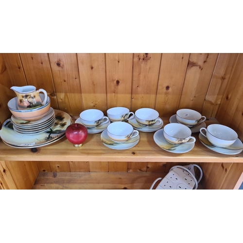 437 - A Japanese Noritake 23 piece tea set. Includes cups and saucers, serving plates, a bowl, and a milk ... 