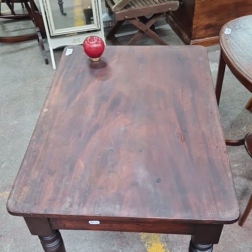 471 - Mid-19th Century Victorian side table in mahogany, featuring turned legs on casters.