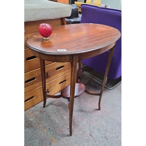 473 - Edwardian oval mahogany side table featuring a central marquetry inlay, elegantly tapered legs, and ... 