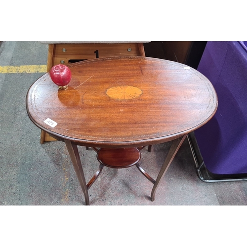 473 - Edwardian oval mahogany side table featuring a central marquetry inlay, elegantly tapered legs, and ... 