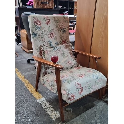 482 - Mid-Century Modern armchair with floral upholstery and wooden armrests. Features a high back and mat... 