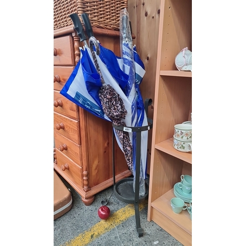 491 - Umbrella stand with assorted umbrellas in blue and white, and patterned designs.