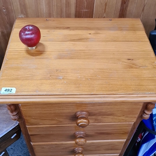 492 - Five-drawer pine chest, featuring rounded wooden knobs and turned column details. Measures approxima... 