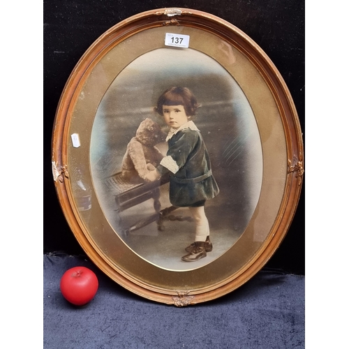 137 - An antique late 19th century photograph of a child with a Teddy Bear. Features hand painted delicate... 