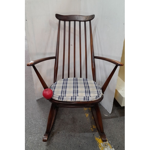 615 - Ercol rocking chair, mid-century modern, crafted from dark-stained wood with spindle back and plaid ... 