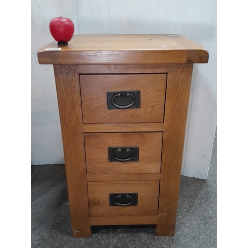 618 - A Solid oak three-drawer nightstand with metal pull handles.