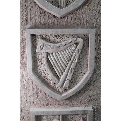 620 - Hand-carved Irish wooden panel featuring four heraldic shields with intricate details, possibly depi... 