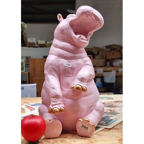 390 - A characterful figure of a hippopotamus in a pink shade with gold tones nails and ears.