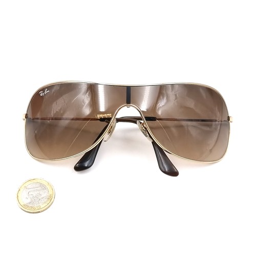 567 - A pair of as new Ray Ban wrap round Italian sunglasses with serial number marks to frames. Comes wit... 