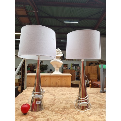 383 - Two tall sleek and stylish tall chrome table lamps. Featuring circular fabric shades.