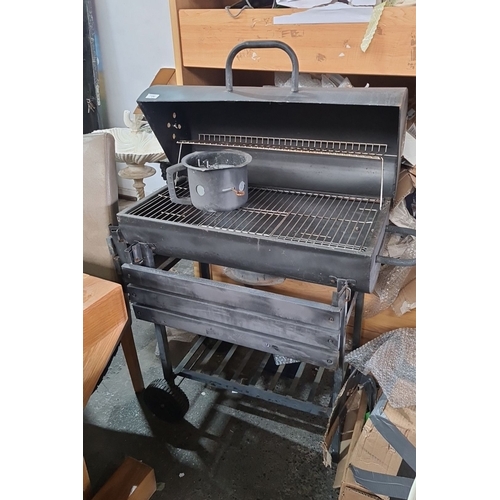 706 - Charcoal barbecue grill with wheels and metal grates. Comes with a hinged lid that has an integrated... 