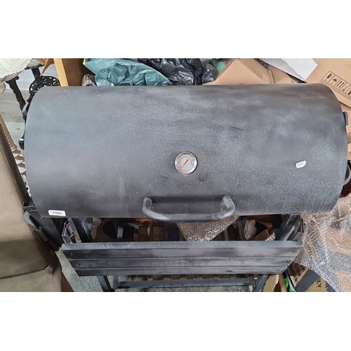 706 - Charcoal barbecue grill with wheels and metal grates. Comes with a hinged lid that has an integrated... 