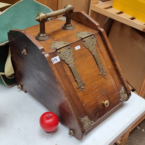 376 - A fine example of a Victorian coal scuttle boasting a brass handle and hardware.