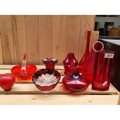 377 - Nine pieces of red glassware including bud vases and bowls.