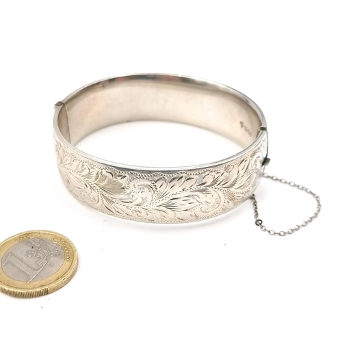 554 - A vintage sterling silver bracelet with foliate detailing to band with hallmarks for London. Set wit... 