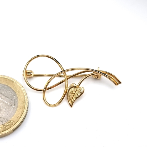 560 - A nine carat gold brooch set with a leaf design with a swirl designed mount. Dimensions 3.5 x 2cm We... 