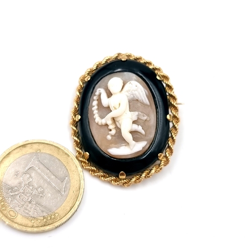 561 - Star Lot : A Victorian gold mourning brooch mounted in a twist rope depicting a finely carved angel.... 