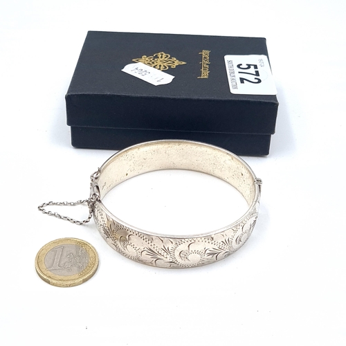 572 - An antique sterling silver bangle with safety chain. Weight 33.67 grams. Boxed.