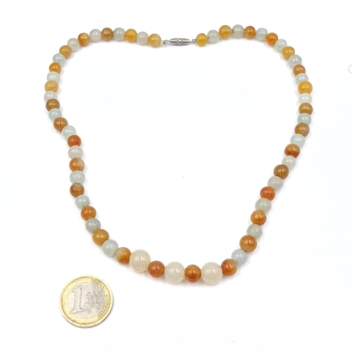 573 - A graduated two tone jade bead necklace set with a twist clasp. Length 40cm. Weight 38.84 grams. Col... 