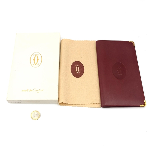 599 - Star Lot : An original very handsome Designer Cartier burgundy leather travel wallet with Cartier ce... 