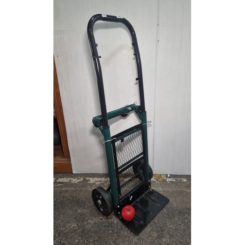 658 - Heavy-duty hand truck with a collapsible frame, black handle, and green mesh back support. Features ... 