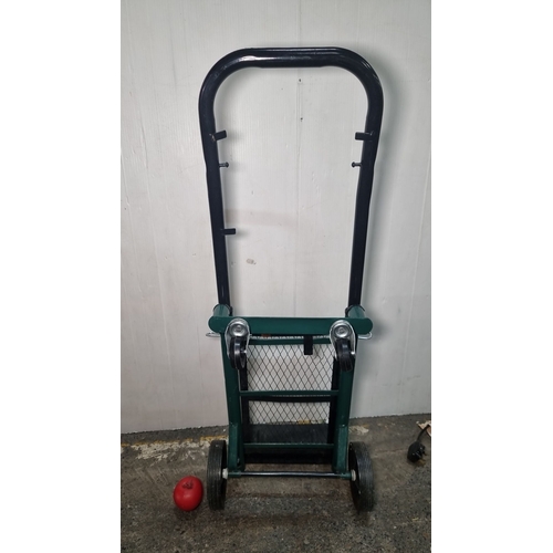 658 - Heavy-duty hand truck with a collapsible frame, black handle, and green mesh back support. Features ... 