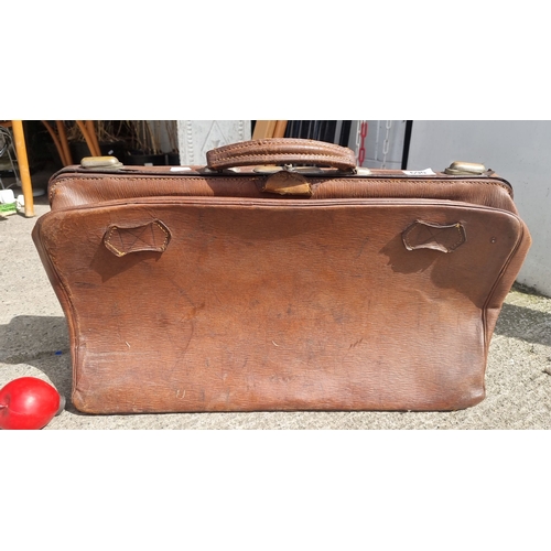 690 - Vintage brown leather suitcase with cloth-lined interior and exterior leather handle. Features compa... 