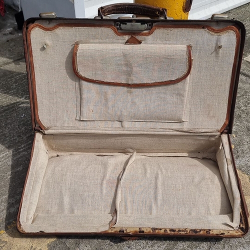 690 - Vintage brown leather suitcase with cloth-lined interior and exterior leather handle. Features compa... 