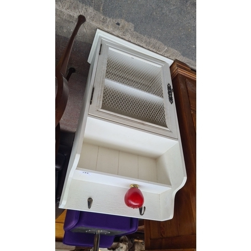 447 - Painted wooden cabinet with mesh door and two shelves. Includes wall hooks.