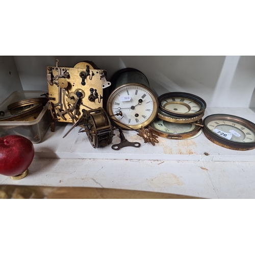 726 - Assorted antique clock parts including movements, faces, hands, and a winding key. Various sizes and... 