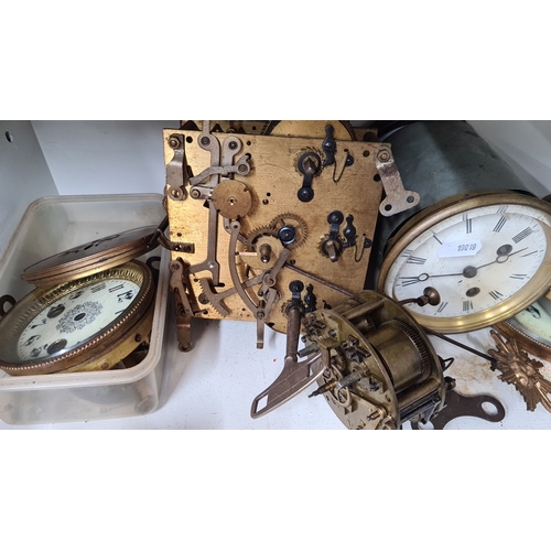 726 - Assorted antique clock parts including movements, faces, hands, and a winding key. Various sizes and... 