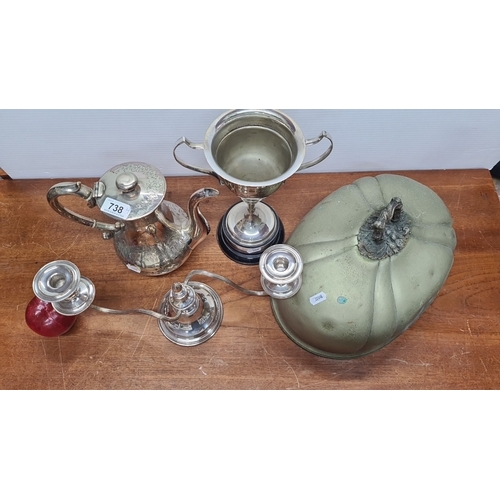 738 - Assorted silver-plated tea set including teapot, trophy cup, two-arm candelabra, and decorative cloc... 