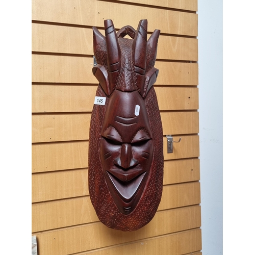 145 - A heavy African hand carved wooden tribal mask with wonderful detail.