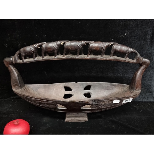 245 - A large hand carved ebony wooden African basket featuring elephant detail to handle.