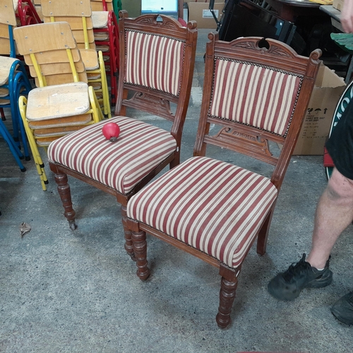 1064 - A lovely pair of Edwardian dining chairs with finely carved back and turned front legs on castors. U... 