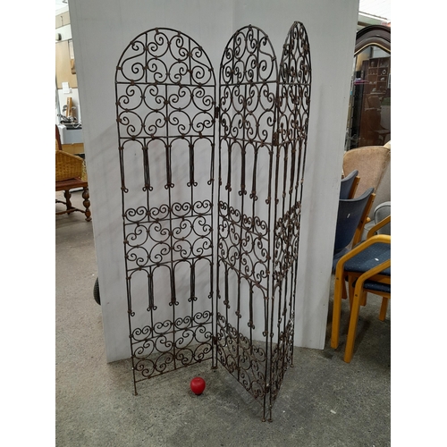 1069 - A wrought iron arched screen divider featuring scroll patterns.