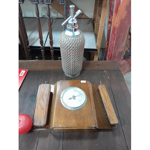 1174 - A vintage soda syphon featuring a mesh detail, together with a wooden weather gauge by Smiths, made ... 