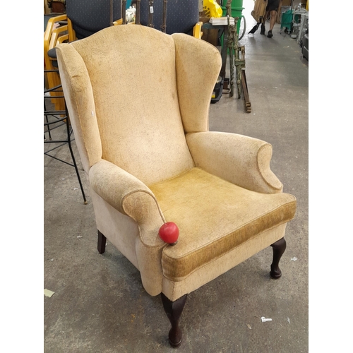 1177 - An extremely comfortable tall wingback armchair upholstered in a beige with hints of red and green r... 