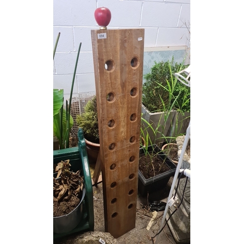 694 - Wooden wine rack with freestanding support. Features a natural finish and twelve circular bottle slo... 