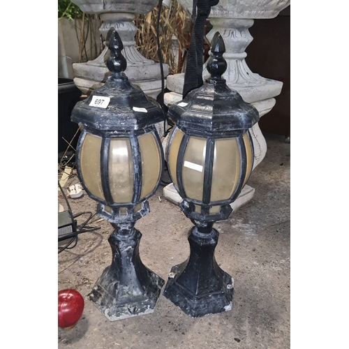 697 - Pair of vintage black metal outdoor lanterns with frosted glass panels and a classic, ornate design.