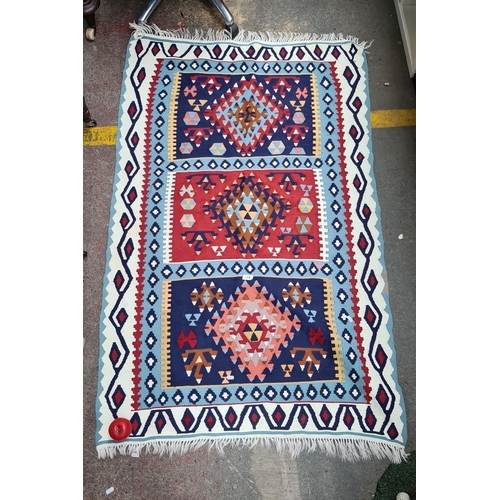 251 - Star Lot : A hand knotted Kilim Rug with geometric patterns in vibrant colors—blues, reds, and white... 