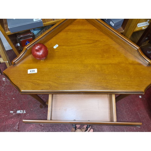 439 - A stylish mid century style corner table. Features a nicely sized pull out drawer to front, brass ha... 