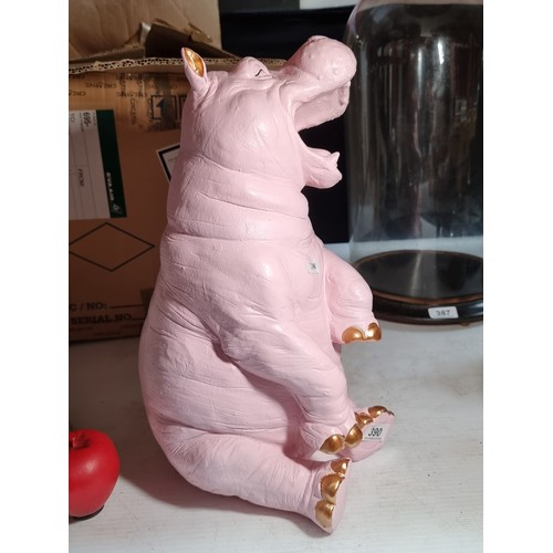 390 - A characterful figure of a hippopotamus in a pink shade with gold tones nails and ears.