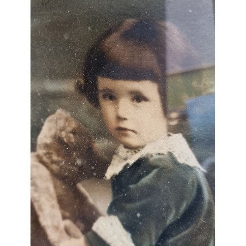 137 - An antique late 19th century photograph of a child with a Teddy Bear. Features hand painted delicate... 