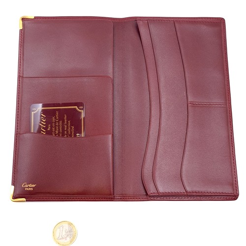 599 - Star Lot : An original very handsome Designer Cartier burgundy leather travel wallet with Cartier ce... 