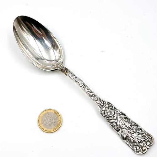 15 - A sterling silver spoon with highly decorated fiddle pattern handle. Length - 18 cms. Weight - 55.07... 