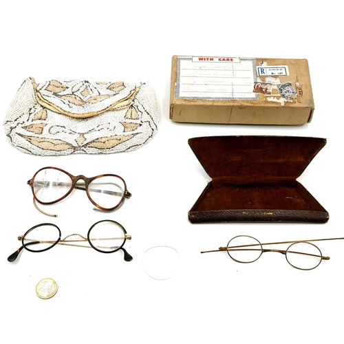 44 - A collection of three antique spectacles. Together with a beaded design clutch bag.