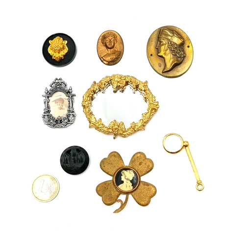 49 - A collection of assorted figural metal mounts. Together with a miniature magnifying glass. Items as ... 