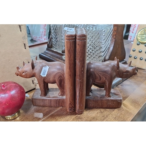 742 - Pair of hand-carved wooden rhinoceros bookends. Exquisitely crafted with intricate details, showcasi... 