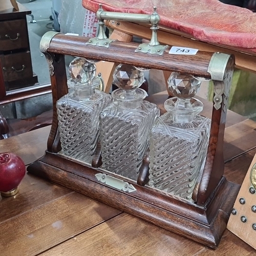 743 - Vintage Oak Tantalus with Three Cut Crystal Decanters. Features brass accents and intricate glass st... 